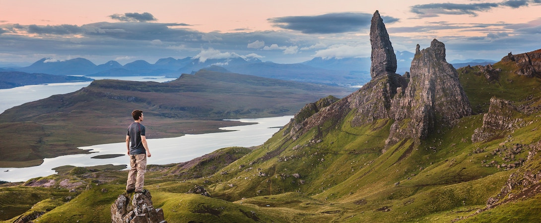 a man standing on the top of a mountain overlooking a mountain range