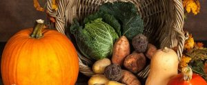 pumpkin and vegetables near a wooden basket