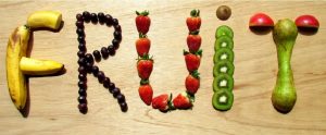 fruit making up the words "Fruit" on a wooden cutting board