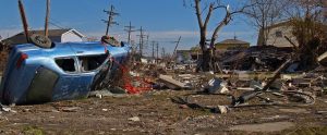 natural disaster in a city with destroyed homes and cars
