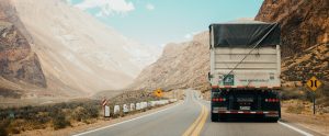 a truck driving down a road in a valley