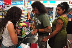 people putting their items from their shopping basket to the cashier check out