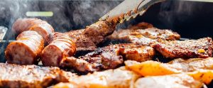 meat being barbecued with a tong