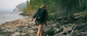 woman with a backpack walking on a beach