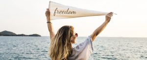 a woman holding a triangular sign saying "freedom"