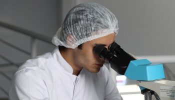 a scientist using a microscope