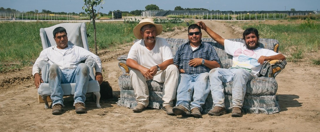 four Hispanics sitting on a couch and a chair in the desert