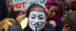 black man wearing an anonymous mask during a protest march