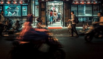 people walking and cycling on a Chinese street