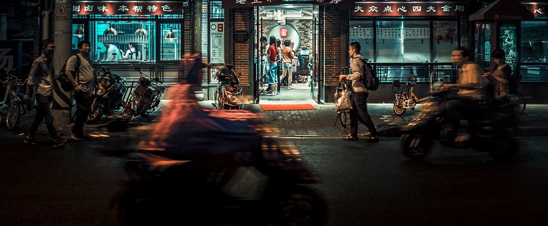 people walking and cycling on a Chinese street