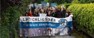 animal activist march through the streets with a banner decrying animal experimentation