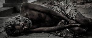 black and white image of a scrawny homeless man