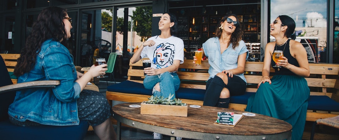 a circle of friends drinking and laughing together
