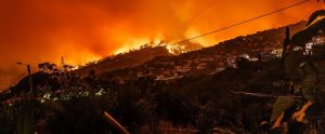 a forest fire near a city built on mountains