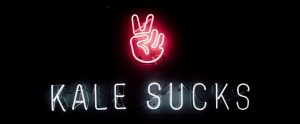 a neon sign that says "Kale Sucks"
