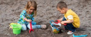 two children playing in a sandbox together