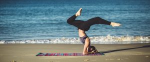 woman doing yoga on a beach
