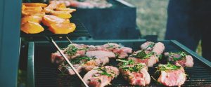 raw meat being cooked on a barbecue