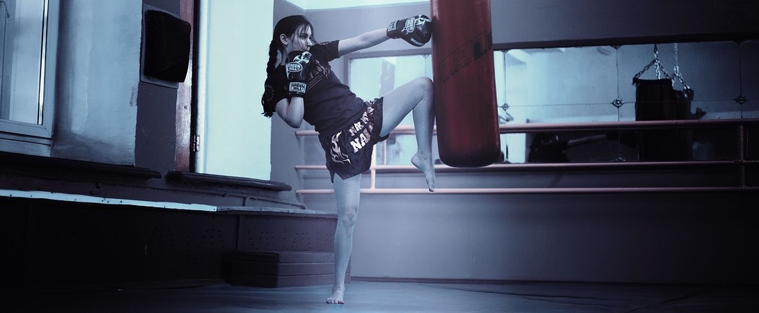 a woman doing kickboxing with a punching bag