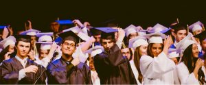 university graduates throwing their hats off