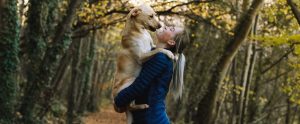 a woman carrying her dog