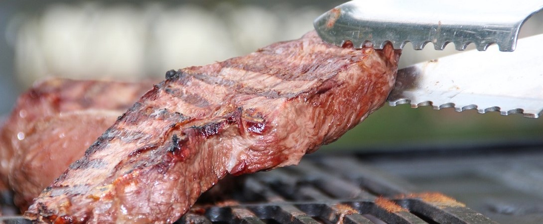 cooked steak being picked up