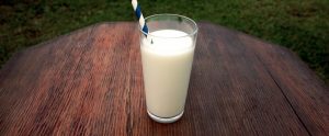 milk in a glass with a straw in it on a table