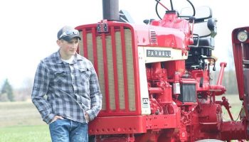 a farmer in front of a red tractor
