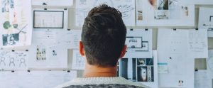 man looking at a board with papers on it