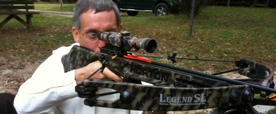 a hunting holding a camouflaged crossbow