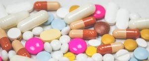 pills in different shapes, sizes and colours sprawled around