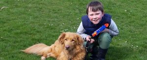 a child sitting next to his pet golden retriever
