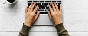 a man typing on a MacBook