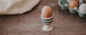 egg with a smiley face on it in an egg cup