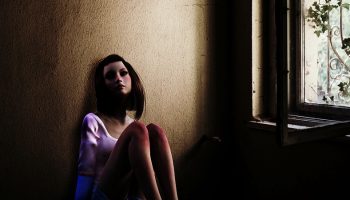 cartoon abused girl sitting against a wall