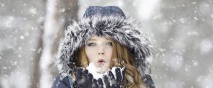 a pale, ginger with a winter coat standing in the winter snow