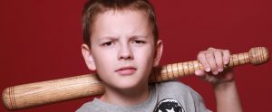 aggressive boy holding a baseball bat in a threatening posture