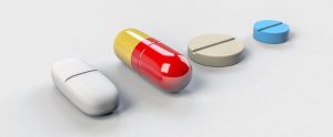 four different colored and shaped antibiotic pills
