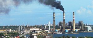 huge factory area with three chimneys emitting huge amount of black smoke