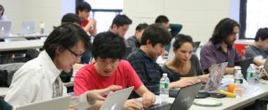 university students in a lecture looking at their computers