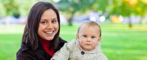 a mother holding her toddler in a park