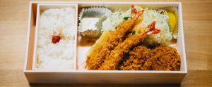 box of Asian food with rice fish and meat