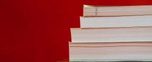 four books piled on top of each other with a red background