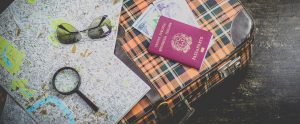 holiday items including a passport, maps and a suitcase