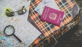 holiday items including a passport, maps and a suitcase