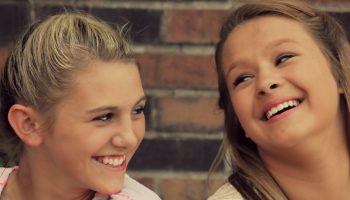two teenage girls smiling at each other