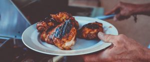 man putting chicken on his plate