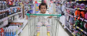 a Chinese baby in a shopping trolley in a supermarket aisle