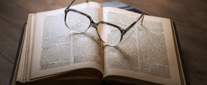 an open book with a pair of glasses on it