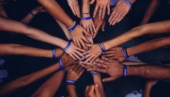 group of people putting their hands in together